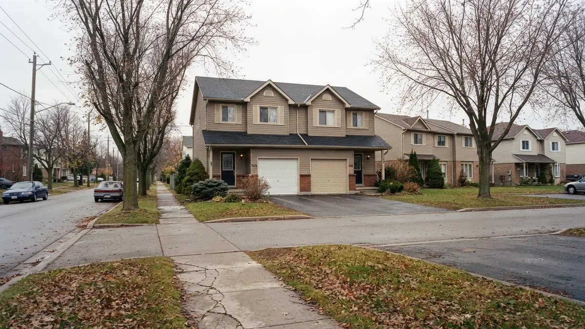 Duplexes and a townhouse row with earth-toned siding on an early-1990s street lined with tall trees - Leak Detection in Spring Lake Farms